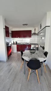 a kitchen with a table and chairs and red cabinets at Apartamento T1 centro Albufeira in Albufeira