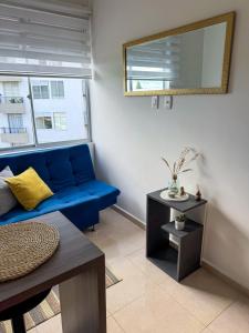 a living room with a blue couch and a table at Modern loft with parking, pool and view! in Armenia