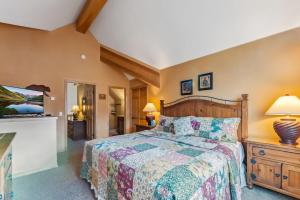 Un dormitorio con una cama grande y un televisor. en Breckenridge Condo with Sauna & Hot Tub Access, en Breckenridge