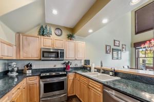 Una cocina con gabinetes de madera y un fregadero. en Breckenridge Condo with Sauna & Hot Tub Access, en Breckenridge