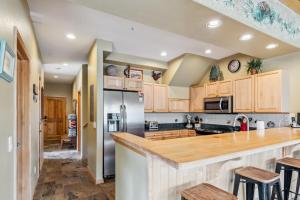 Una cocina con gabinetes de madera y encimera. en Breckenridge Condo with Sauna & Hot Tub Access, en Breckenridge