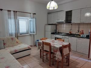 a kitchen with a table and chairs and a couch at Apartments by the sea Povlja, Brac - 5644 in Povlja +11 photos