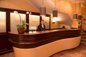 a woman standing at a reception desk in a lobby at Hotel Schlicker in Munich