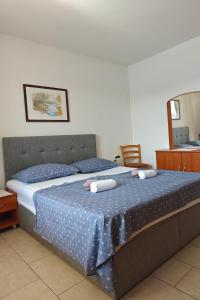 sypialnia z łóżkiem i dwoma ręcznikami na nim w obiekcie Apartments by the sea Stara Novalja, Pag - 13938 w mieście Stara Novalja