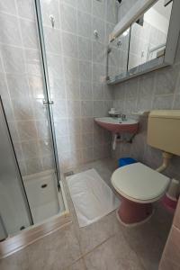 łazienka z prysznicem, toaletą i umywalką w obiekcie Apartments by the sea Stara Novalja, Pag - 13938 w mieście Stara Novalja +27 zdjęć