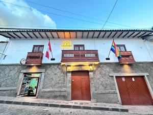 Un edificio con dos puertas y dos banderas. en Casona Libertrek Inn, en Cusco