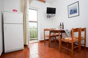 a kitchen with a table and a white refrigerator at Apartments by the sea Promajna, Makarska - 2588 in Promajna +26 photos
