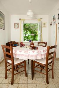 a dining room with a table and chairs and a window at Apartments by the sea Promajna, Makarska - 2588 in Promajna