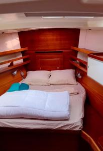 a bedroom with a large bed with a wooden headboard at LUNA BAY, voilier 3 cabines 2 sdb en ville in Sète