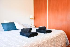 two towels sitting on top of a bed at Departamento Centenario con hermosa vista in San Martín de los Andes