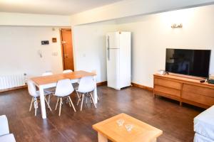 a living room with a table and chairs and a tv at Departamento Centenario con hermosa vista in San Martín de los Andes