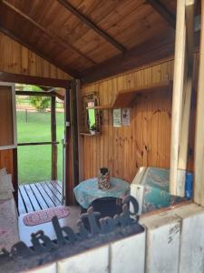 ein Inneres eines Hauses mit einem Tisch und einer Veranda in der Unterkunft Cabana Hostel nas Árvores EcoPark in São Pedro + 37 Fotos