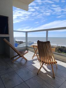 a balcony with a table and chairs and a view of the ocean at Rest Departamento con vista al mar in San Bernardo