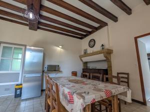 a kitchen with a table and a stainless steel refrigerator at Gîte à la ferme avec jardin privé, clim et visite de l'exploitation près d'Argenton-sur-Creuse - FR-1-591-321 in Cluis +14 photos