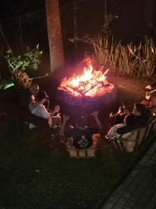 a group of people sitting around a fire pit at Recanto Gu&Gui in Camanducaia