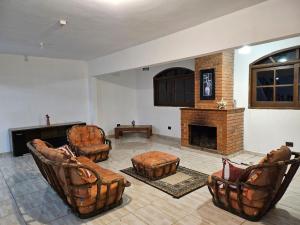 a living room with chairs and a fireplace at Recanto Gu&Gui in Camanducaia