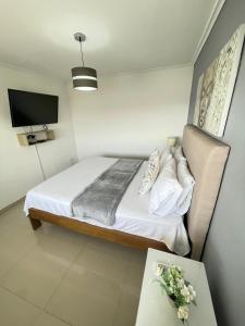 ein Schlafzimmer mit einem Bett, einem Tisch und einem Fernseher in der Unterkunft Cabrero Beach 906 in Cartagena de Indias + 12 Fotos