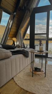 a living room with a couch and a table at Cabana A-Frame pé na represa com translado de barco in Natividade da Serra
