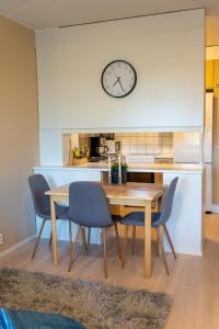 a kitchen with a table and chairs and a clock on the wall at Cosy one bedroom apartment with balcony in Rovaniemi