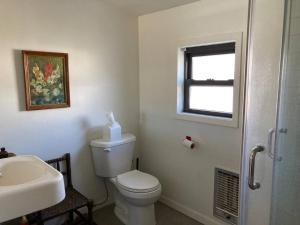 a bathroom with a toilet and a sink and a window at Prickly Pear Rancher - Close to Downtown in Marfa +19 photos