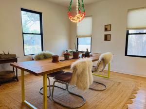 a dining room with a wooden table with furry chairs at Prickly Pear Rancher - Close to Downtown in Marfa