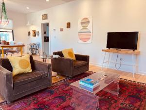 a living room with two couches and a flat screen tv at Prickly Pear Rancher - Close to Downtown in Marfa