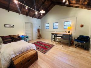 a bedroom with a bed and a desk and a table at Prickly Pear Rancher - Close to Downtown in Marfa