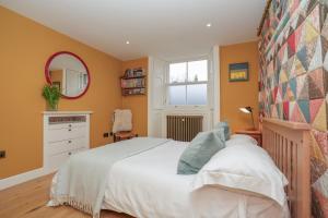 Un dormitorio con una cama blanca y un espejo. en Luxury Wood panelled West End GF Flat, en Edimburgo