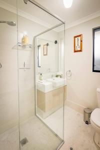 a bathroom with a glass shower and a sink at Stables Lane Retreat in Busselton +19 photos