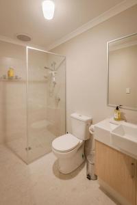 a bathroom with a toilet and a shower and a sink at Stables Lane Retreat in Busselton