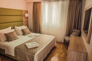 a hotel room with a bed and a chair at Family-friendly apartments with swimming pool Mandre, Pag - 24196 in Kolan +23 photos