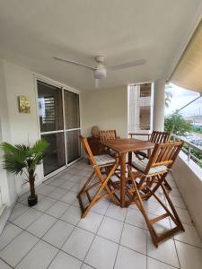 a dining room with a table and chairs on a balcony at Le Marin - T3 vue sur Nouvelle Marina in Le Marin