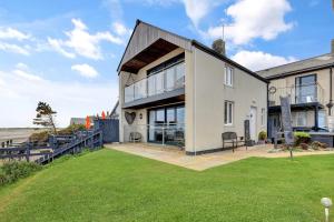 an exterior view of a house with a lawn at Beach House - North East Escapes in Boulmer