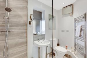 a bathroom with a toilet and a sink and a shower at Coastal Retreat - North East Escapes in Boulmer +17 photos