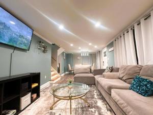 Una sala de estar con un sofá y un televisor. en 511b) Massive 4 bedroom with fenced yard, en Buffalo