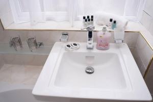 a white bathroom sink with a bottle of soap at Blossom House* For Large Groups* Near Sutton Park* in Birmingham +37 photos