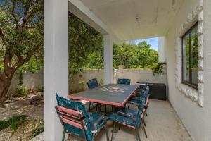 a porch with a table and chairs on a patio at Apartments and rooms by the sea Brela, Makarska - 24416 in Brela