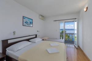 a bedroom with a bed and a large window at Apartments and rooms by the sea Brela, Makarska - 24416 in Brela