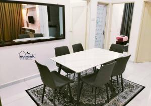 a dining room with a white table and chairs at Harmonia Homestay Terengganu FREE WIFI in Bukit Payong