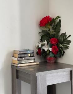 a table with books and a vase of flowers at Aqua Villa in Willemstad +29 photos