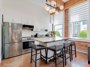 une cuisine avec une table, des chaises et un réfrigérateur dans l'établissement Old Town Retreat-your artful escape in Victoria’s historic Old Town by Victoria Prime!, à Victoria