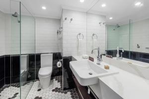 a bathroom with a sink and a toilet and a tub at View Brisbane in Brisbane