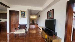 ein Wohnzimmer mit einem Flachbildfernseher an der Wand in der Unterkunft Essential Life La Cuaba Casa de Campo Amenities in Pedro Brand