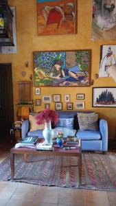 a living room with a blue couch and a table at Vila Santa Rosa Guest House in Ilhabela