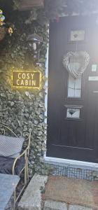 a black door with a sign that reads cosy cabin at BELFAST COSY CABIN in Belfast +10 photos