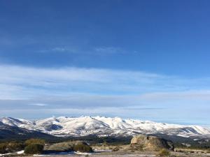 Una cadena montañosa con montañas cubiertas de nieve en la distancia en Casa Ensueño-Los Sitios de Aravalle, en Gilgarcía