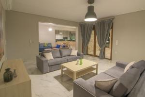 a living room with two couches and a table at Petra Luxury Rooms and Apartments in Korinthos