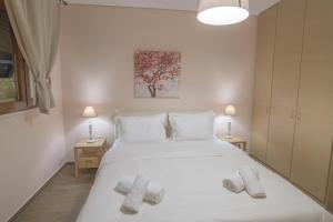 Un dormitorio con una cama blanca con toallas. en Petra Luxury Rooms and Apartments en Korinthos