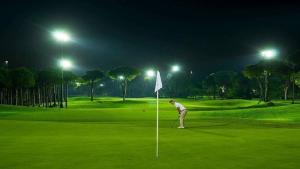 a man playing golf on a golf course at night at Vista Cana punta cana beach Paradise Pool & Lake golf Condo in Punta Cana