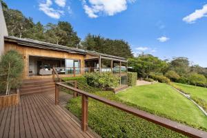 a house with a wooden deck and a yard at 'Yambanool' Red Hill Escape in Red Hill